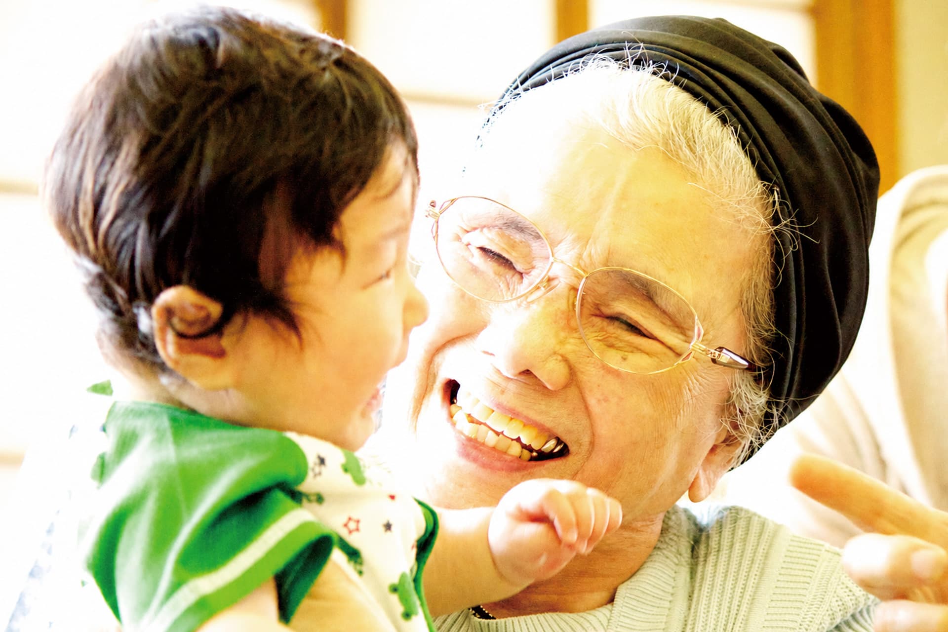 赤ちゃん先生の授業 — 介護施設で笑顔のお年寄りと赤ちゃんが触れ合う様子